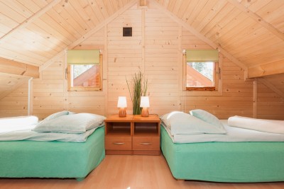 Fotografia przedstawia łóżko w pokoju - Domki SOLEI | Pobierowo (wypoczywaj nad morzem) 