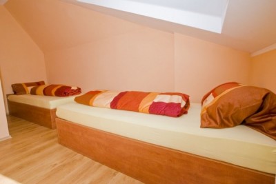 Zdjęcie przedstawia łóżko w pokoju - Pensjonat EUROBAŁTYK | Rewal (wypoczywaj nad morzem) 