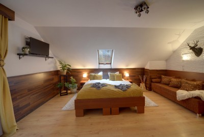 Pokój z łazienką, podwójnym łóżkiem, kanapą i balkonem.
