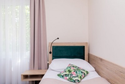 Fotografia przedstawia łoże w domu gościnnym Flamingo